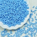 Close-up of sky blue peanut glass beads in a white floral dish for DIY jewelry making - Sky Blue