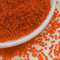 Macro shot of 3mm orange transparent glass seed beads on a white textured background - 3mm / 10g/Pack / Orange