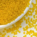 Macro detail of 3mm bright yellow transparent glass seed beads for DIY jewelry making - Dark Yellow