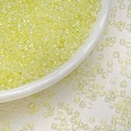 Macro shot of 3mm iridescent pale yellow glass seed beads for DIY jewelry making - Transparent Yellow