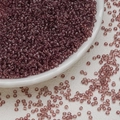 Macro shot of 3mm purple glass seed beads in a white ceramic dish for DIY jewelry - Light Coffee