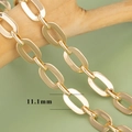 Close-up of 11.1mm wide 18K gold plated cross chain links on a wooden branch detail - 11.1mm Flat Oval Ring Link Chain Style (C17209) / 1m