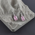 Detail view of silver earrings with rectangular pink zircon stones on grey stone background - Pink Silver (M99903)