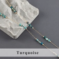 Close-up of turquoise beads on a gold stainless steel chain over a textured rock - Turquoise Style (C25508)