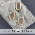 Dettaglio di moschettoni ovali dorati per gioielli 17,8x12,3mm su sfondo in pietra - Stile Ovale Piccolo Oro (M110906)