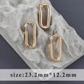 Dettaglio macro di moschettoni a D placcati in oro 18k su pietra grigia, 23,2x12,2 mm - Stile Ovale Grande Oro (M110909)