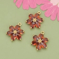 Drei 18k vergoldete Blumenanhänger mit dunkelroten Kristallblättern und goldener Mitte - Gold - Weinrot