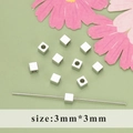 3mm silver cube beads spacer for jewelry making on a pastel green background - Polished Cube Style (MB6109B)