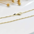 Macro shot of 18K gold plated necklace with delicate twisted chain and lobster clasp - Water Wave Chain (1.8mm)