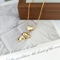 Macro shot of gold heart pendant with colorful zircon stones on capital letter F - Letter F