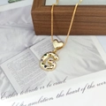 Detail of gold letter G pendant with colorful cubic zirconia on a heart clasp - Letter G