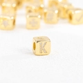 Detailaufnahme der 18k vergoldeten Würfelperle mit Zirkonia-Inlay für den Buchstaben K - Buchstabe K