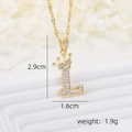 Macro view of gold letter L pendant with crown detail and sparkling cubic zirconia - Gold L