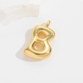 Macro shot of gold puffy bubble letter B pendant with a polished mirror finish on white stone - Small Letter Pendant / Letter B