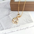 Macro shot of gold letter Q pendant with multi-colored gemstones and heart charm detail - Letter Q