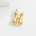 Macro shot of 3D puffy balloon gold letter H pendant with polished finish and white stones - Letter H