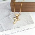Detail of a gold letter T pendant with multicolored zircons and heart-shaped bail - Letter T