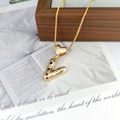 Detailed macro view of a gold-tone letter V pendant with colorful stones on a box chain - Letter V