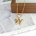 Detail of a gold letter W pendant featuring colorful zircon stones and a heart-shaped bail - Letter W