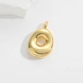 Macro shot of gold-plated puffy letter pendant on white stone with polished finish - Letter O