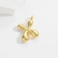 Macro view of gold 3D balloon alphabet X pendant with polished metallic finish - Letter X