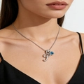 Close-up of silver letter P necklace with square blue gemstone on a model's neck - Silver P