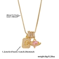 Macro view of gold initial O pendant with zircon cubic stones and pink heart charm - Box Chain / Gold O