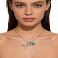 Macro detail of silver necklace featuring a crystal letter W and blue gemstone pendant - Silver W