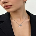 Silver letter N necklace with blue gemstone and zircon inlay on a female model - Silver N