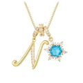 Macro detail of gold letter N pendant with blue zircon and snowflake crystal design - Gold - Letter N