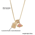 Close-up of golden box chain necklace with zircon 'X' pendant and pink heart gem - Box Chain / Gold X