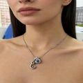 Detailed view of silver letter E necklace with blue gemstone and pavé stones on model - Silver E
