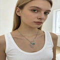 Close-up of elegant silver necklace featuring blue gemstone pendant on a female model - Silver I