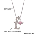 Macro view of crown letter L pendant with pink heart Saturn charm on silver chain - Silver Letter L Style