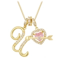 Macro detail of gold necklace with pink heart gem, arrow pendant and zircon crystal letter - Letter U / Gold