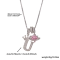 Detailed view of silver necklace with crown letter U pendant and pink heart stone - Silver Letter U Style