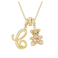 Detailed macro view of golden bear pendant with pink heart crystal and crystal letter C - Gold C
