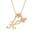 Close-up of gold letter H pendant and pink heart saturn charm on a delicate cross chain - Letter H / Gold