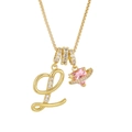 Macro detail of gold letter L pendant with pink heart zircon and sparkling crystals - Letter L / Gold