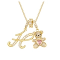 Detailed macro view of gold letter K and teddy bear pendant with pink heart stone - Gold H