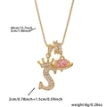Detail of gold necklace with letter S pendant, crown motif and pink heart charm - Gold Letter S Style