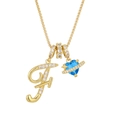 Close-up of golden letter F pendant with blue heart planet charm on a fine chain - Gold F