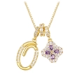 Detailed macro view of gold letter O pendant and purple zircon clover necklace - Gold O