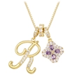 Detailed macro of gold plated letter R pendant and purple zircon clover necklace - Gold R