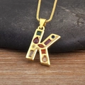 Detalle del colgante letra K de oro con piedras de circonita de colores vibrantes - Letra K