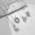 Sparkling zircon encrusted LOVE letter necklaces with elegant silver chains on stone pedestal - Letter A / Silver
