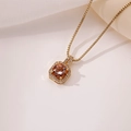 Detalle del colgante de frasco de perfume dorado con gema naranja y circonitas pavé - Naranja