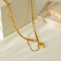 Macro shot of gold-plated heart pendant and mixed link chain against a stone background - Gold Heart Necklace (HC6163)