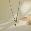 Macro detail of minimalist two-tone titanium steel necklace with gold sphere pendant - Gold and Silver Two-tone Barbell Style (HC422)