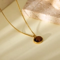 Golden necklace featuring an oval tiger eye gemstone pendant on a textured background - Oval Minimalist Style (HC406)